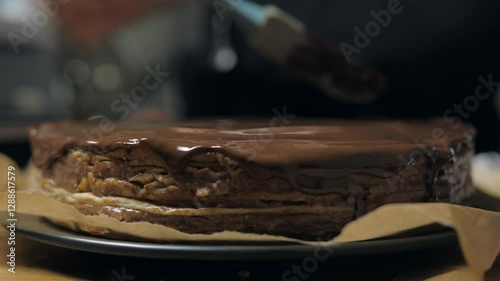 Chocolate glaze is poured over a cake base - closeup