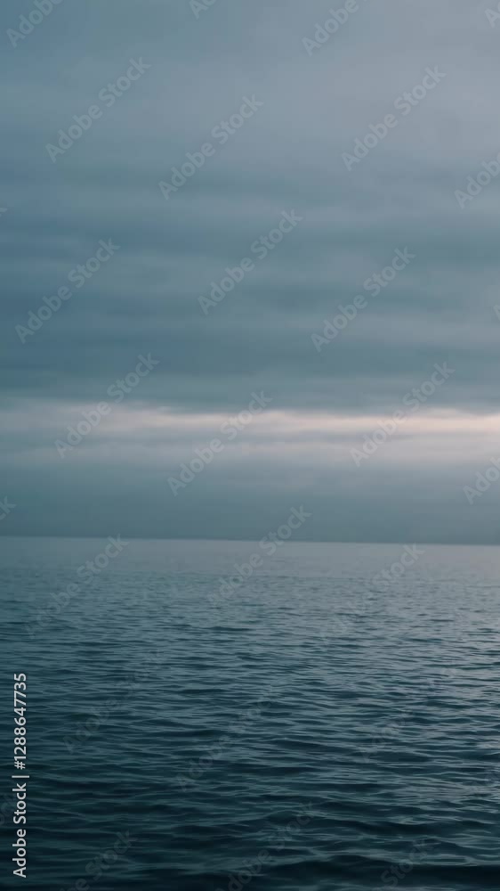 A serene video of a vast ocean under a cloudy sky, captured from a low-angle perspective, emphasizing tranquility and endless horizons. Mobile wallpaper ratio. A serene video of a vast ocean under a cloudy sky, captured from a low-angle perspective, emphasizing tranquility and endless horizons. Mobile wallpaper ratio.
