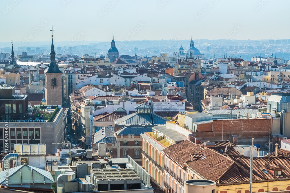 Fototapeta premium Panoramic view of Madrid historic center with a focus on traditional rooftops, churches, and iconic domes. This aerial image captures the essence of the city's architectural beauty from above