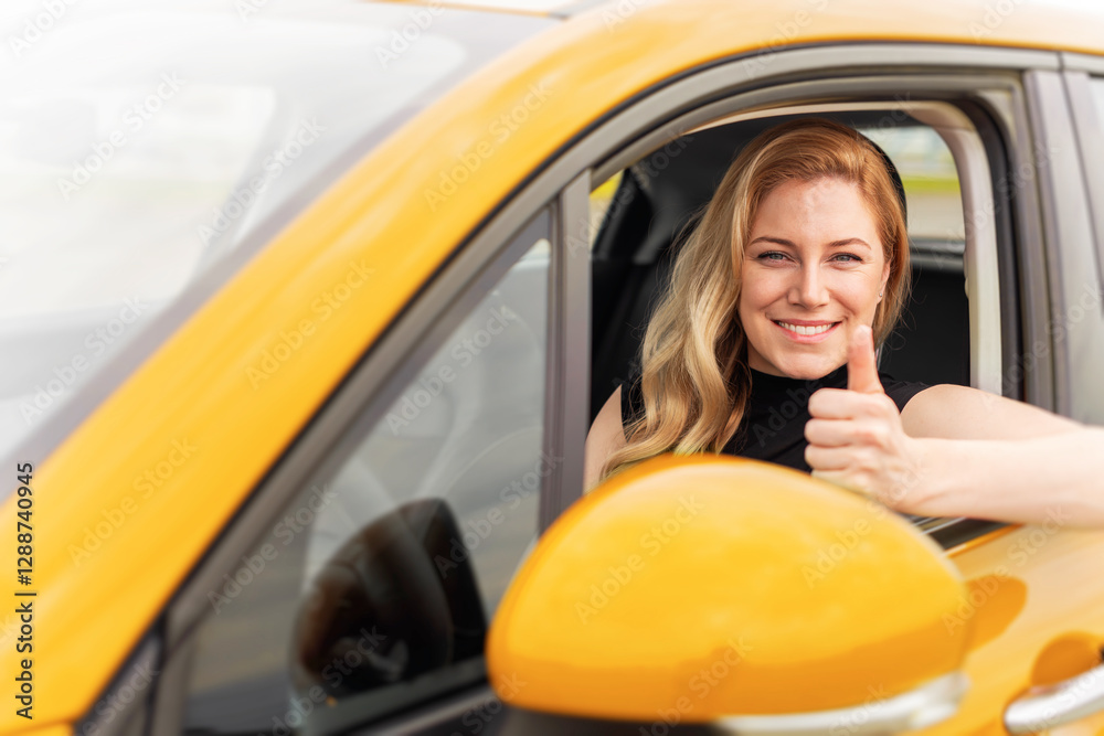 A confident blonde woman sits in a yellow car, smiling and giving a thumbs-up through the window, symbolizing success, happiness, and independence.
