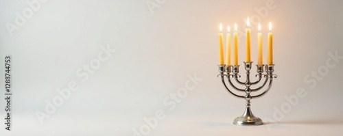 Golden Hanukkah candles glow brightly in a silver candelabrum on white background, candelabrum, candles, hanukkah