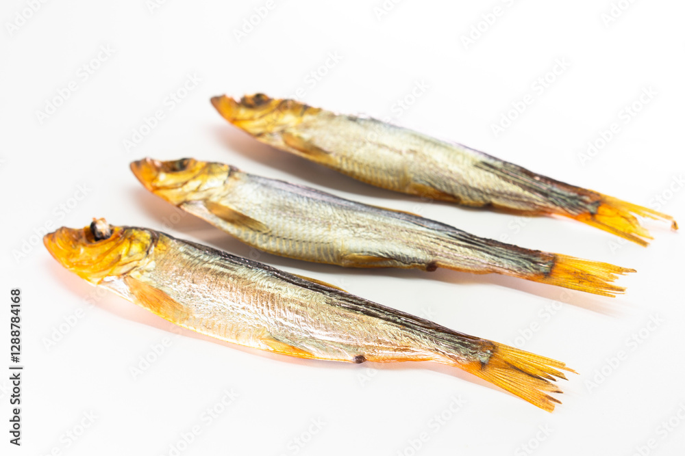 Hot smoked whole herrings on kitchen table. smoked fish isolated on white Hot smoked whole herrings on kitchen table. smoked fish isolated on white