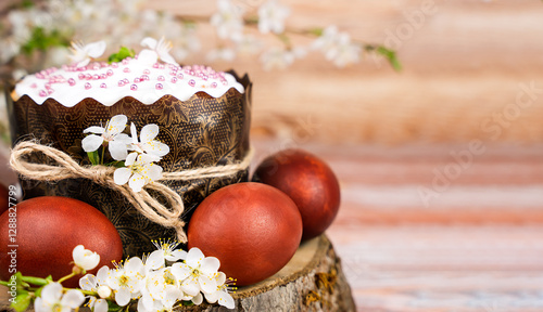 Easter composition with Easter and cake colored eggs on the wooden background. Copy space. Close-up. Selective focus.