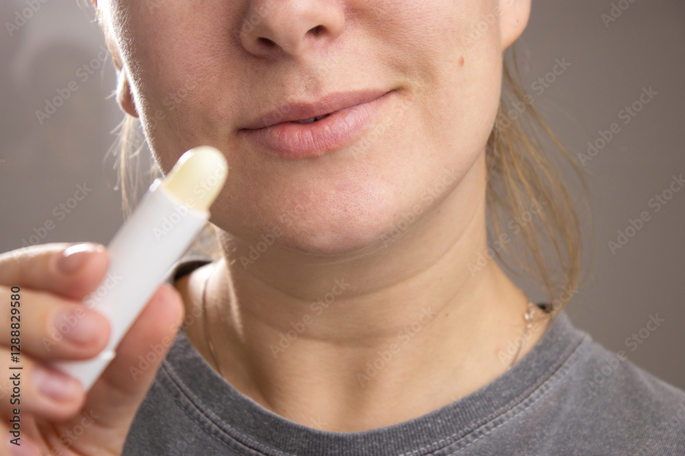 Close up of a caucasian woman holding a hygienic lip balm stick for lips