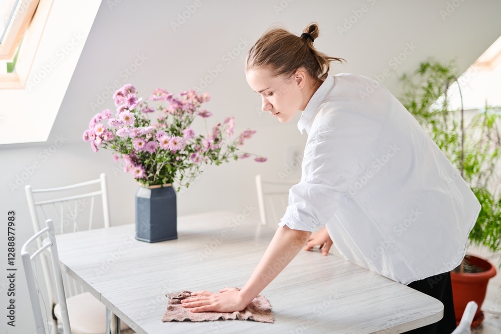 Portrait of a beautiful blonde girl cleaning the house, wiping the table Portrait of a beautiful blonde girl cleaning the house, wiping the table