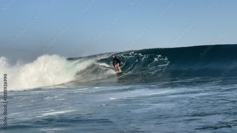 Slow motion video of adult male surfer riding powerful wave in Indian Ocean.Wide angle shot Slow motion video of adult male surfer riding powerful wave in Indian Ocean.Wide angle shot