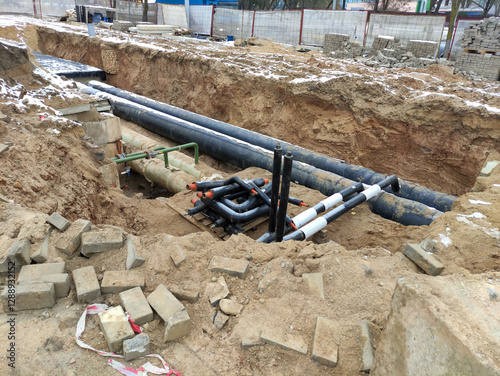Construction site with laying underground communications. Reconstruction of the heat pipeline. The trench contains insulated pipes intended for heating and water supply systems.