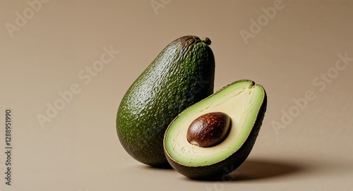 Avocado split in half with seed on beige