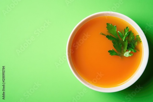 Bright, orange soup garnished with fresh cilantro, set against v