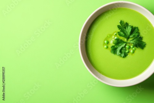 Vibrant green soup garnished with fresh herbs, set against contr