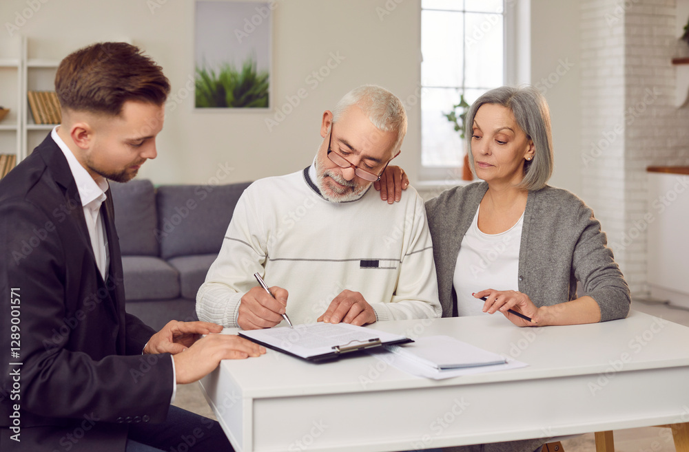 Fototapeta premium Elderly couple clients signs a contract with a real estate agent, financial consultant, or insurance adviser, at home. They finalize agreements related to real estate and financial matters.
