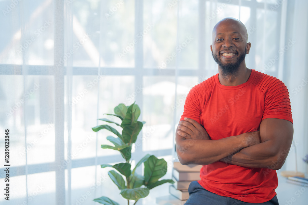 Portrait of a smiling african american man standing with arms crossed in a home office, exuding confidence and professionalism with a bright window and houseplant in the background Portrait of a smiling african american man standing with arms crossed in a home office, exuding confidence and professionalism with a bright window and houseplant in the background
