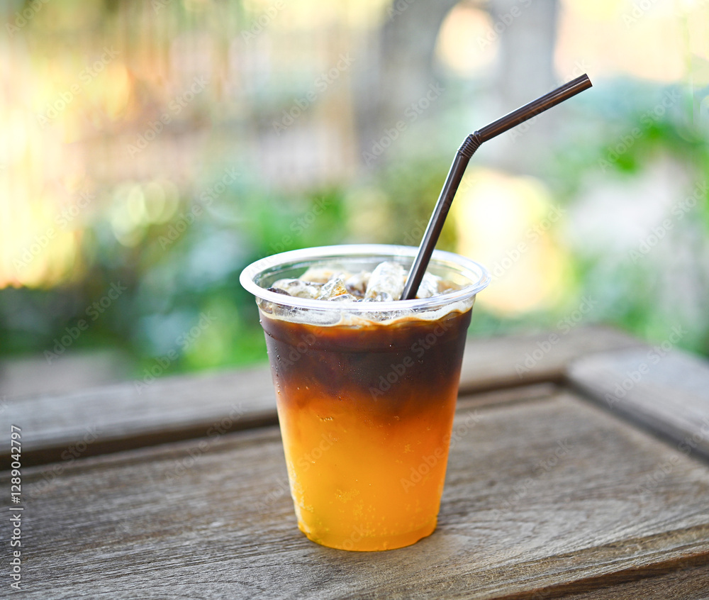 A glass of iced coffee mixed with orange juice. Looks delicious, smells fresh. A glass of iced coffee mixed with orange juice. Looks delicious, smells fresh.