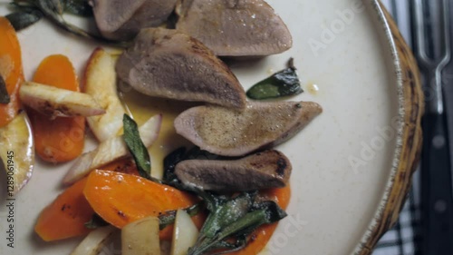 A close-up of a finished dish. This is veal with root vegetables and sage