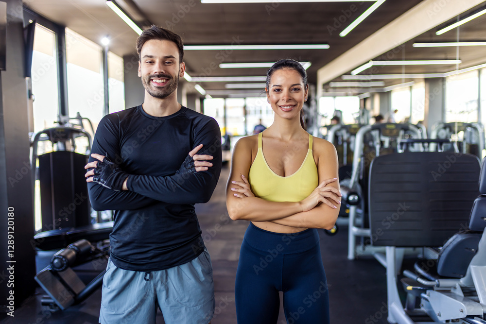 Two gym partners pose with their arms crossed in the gym. Two gym partners pose with their arms crossed in the gym.