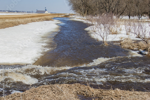 water from spring snow melt running down the road ditch photo