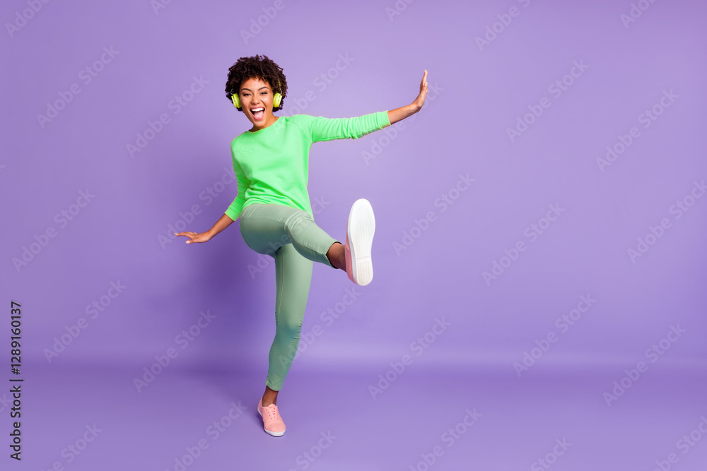 Full length body size photo of wavy ecstatic overjoyed shouting girlfriend dancing listening to music pretending to be kicking with leg near empty space isolated over violet color pastel background Full length body size photo of wavy ecstatic overjoyed shouting girlfriend dancing listening to music pretending to be kicking with leg near empty space isolated over violet color pastel background