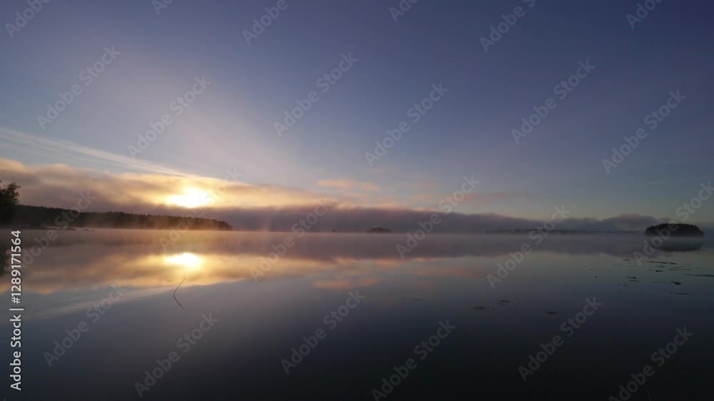 Scenic morning view of clouds on a lake with reflection of sun at sunrise Scenic morning view of clouds on a lake with reflection of sun at sunrise