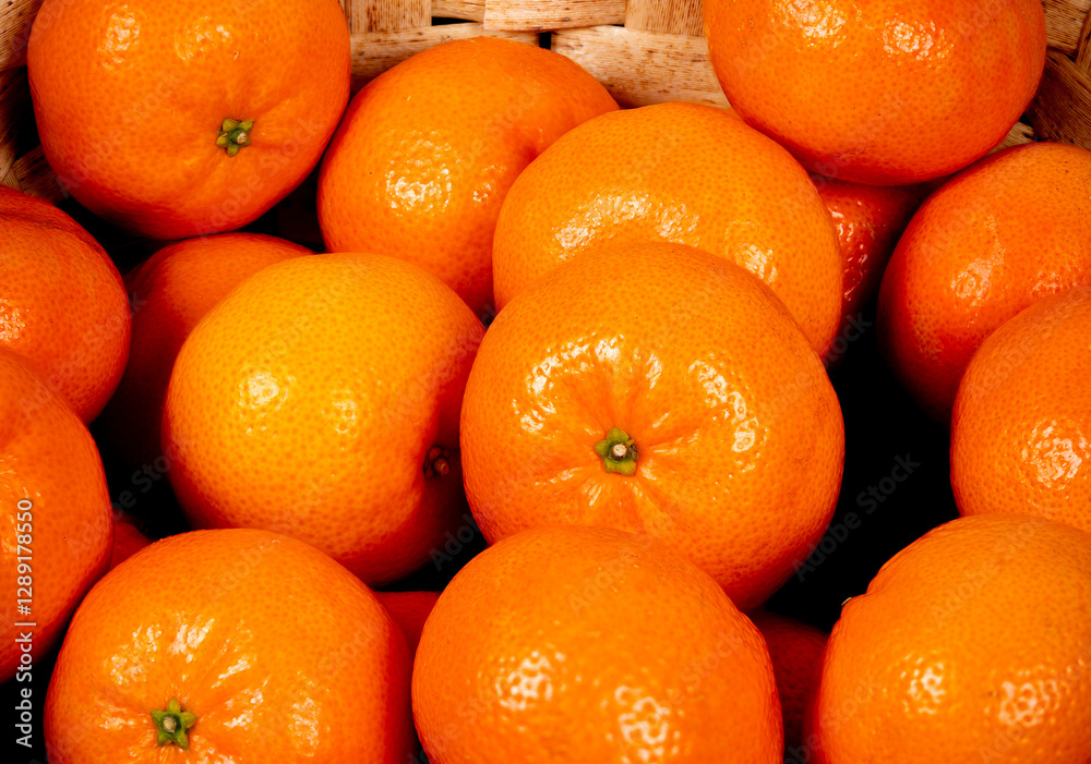 Fresh tangerines displayed in a woven basket at a local market Fresh tangerines displayed in a woven basket at a local market