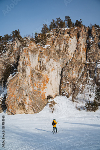 Winter Adventure A skilled crosscountry skier navigates a serene snowy landscape, with a majestic rock formation in the background, creating a breathtaking scene photo