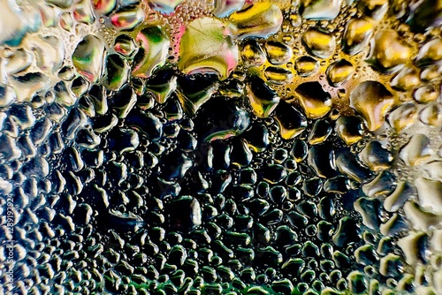 Close-up of water drops on metal surface in high resolution showing condensation of water droplets on metal surface. Intricate patterns and different sized water droplets create a beautiful abstract