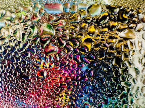 Close-up of water drops on metal surface in high resolution showing condensation of water droplets on metal surface. Intricate patterns and different sized water droplets create a beautiful abstract