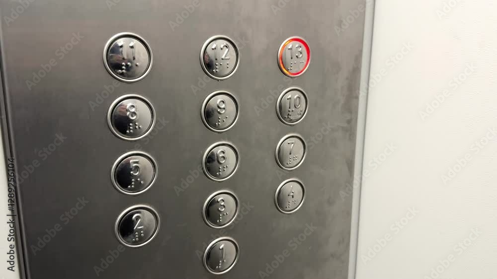 Silver buttons in the elevator for calling floors with red LED light in a minimalist design framed in a round shape
