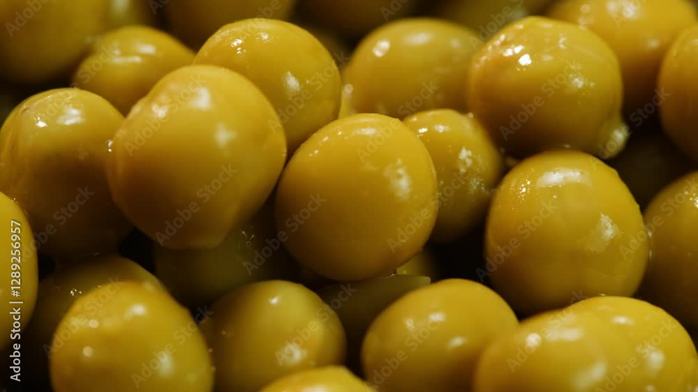 Marinated pickled sweet green peas canned food, rotation in circle. Take canned green pea kernels with a fork Marinated pickled sweet green peas canned food, rotation in circle. Take canned green pea kernels with a fork