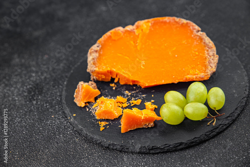 Aged cheese Mimolette or cheddar fresh tasty food dish delicious gourmet food background on the table rustic food top view copy space