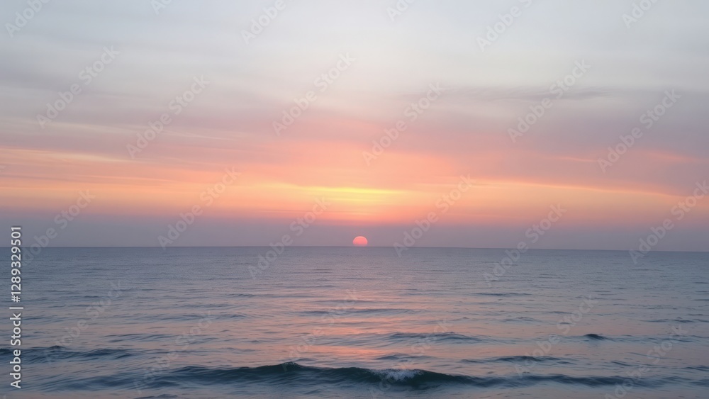 Obraz premium Soft pastel sunset over the calm ocean, with gentle hues of pink, purple, and blue blending in the sky. The tranquil scene captures the serene beauty of nature.