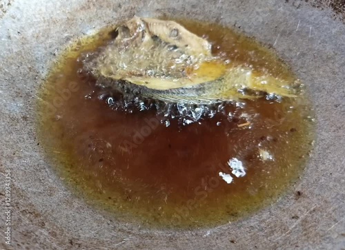 salted fish fried in a skillet with boiling hot oil