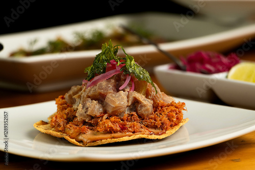 Marlin's tostada with some tuna fish on top, some cilantro, and another food in the back
