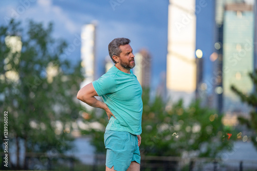 Pain in back after sport. How to run correctly. Man with spine injury. Hurt while jogging outdoors. Muscle pain after sport workout. Back spasm during sport. Rheumatism affecting movement.