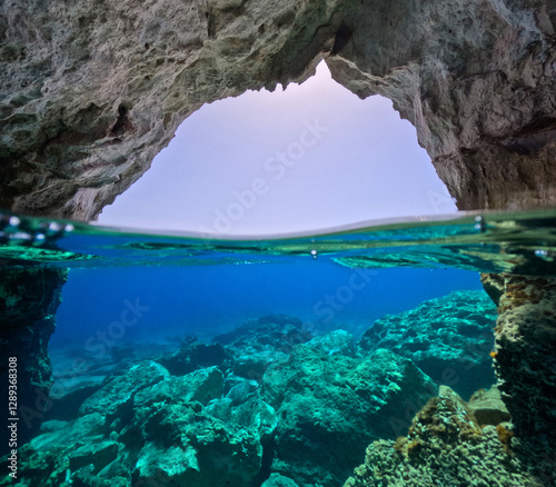 Underwater split photo of beautiful volcanic white rock caves with emerald clear sea