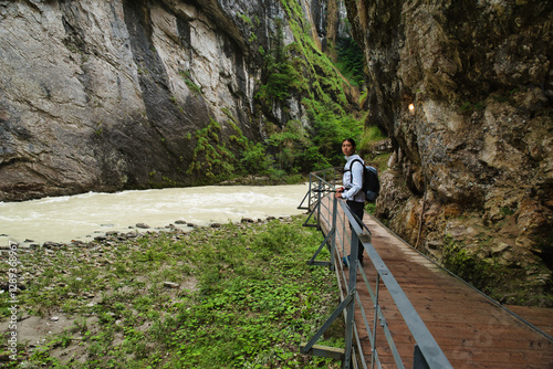 Girl hiker walking in the canyon of the Aar Gorge - Aareschlucht on the river Aare in the canton of Bern, Switzerland. With its footbridges for hiking. Interlaken