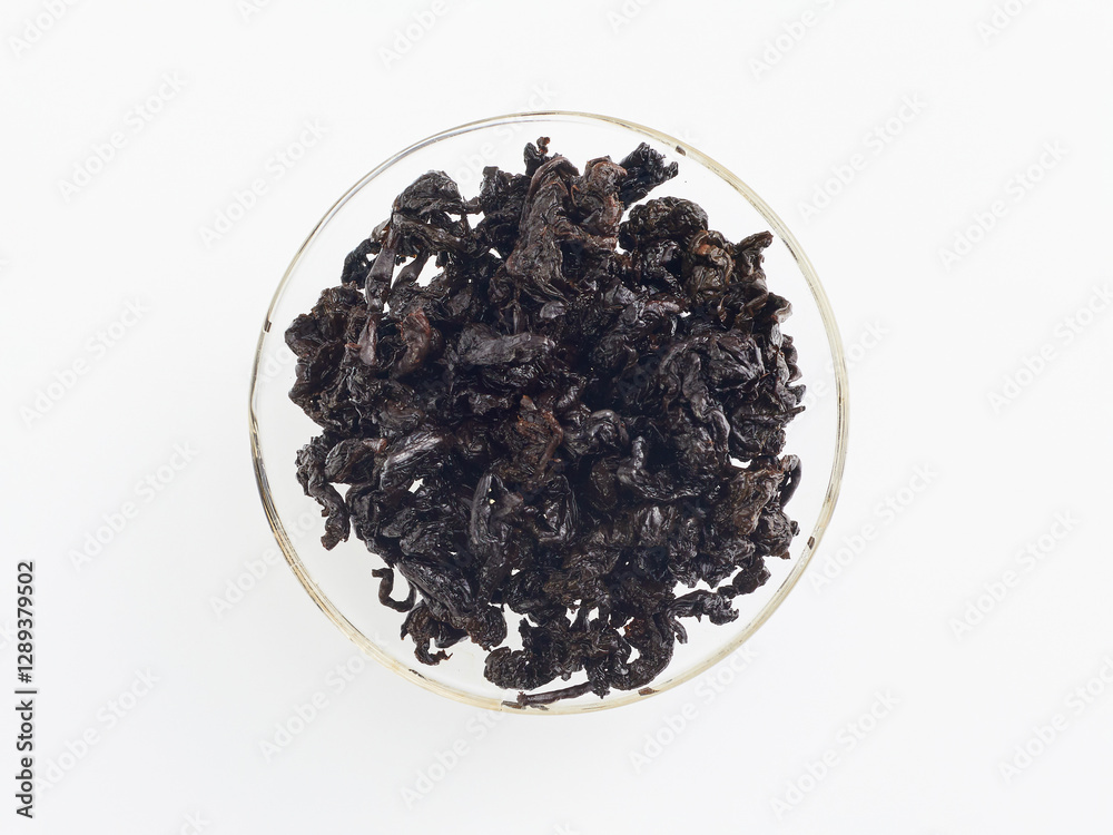 brewed tea leaves in a transparent cup, photo above on a white background brewed tea leaves in a transparent cup, photo above on a white background