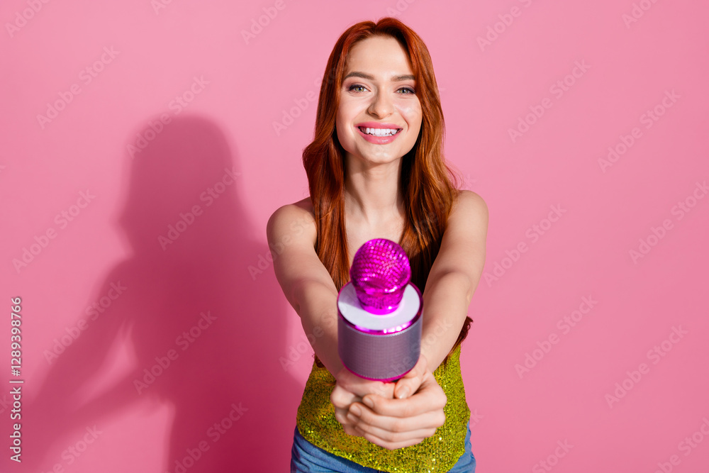 Photo of pretty young woman give microphone you wear shiny top isolated on pink color background Photo of pretty young woman give microphone you wear shiny top isolated on pink color background