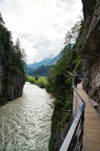 Girl hiker walking in the canyon of the Aar Gorge - Aareschlucht on the river Aare in the canton of Bern, Switzerland. With its footbridges for hiking. Interlaken
