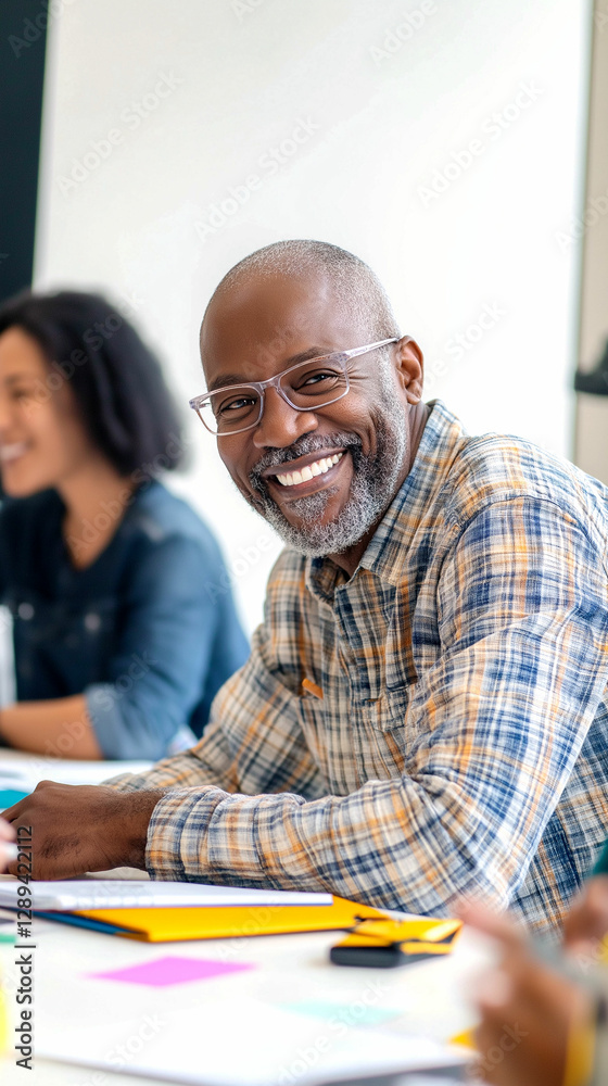 Smiling man in plaid shirt enjoying a collaborative meeting in a bright office space Smiling man in plaid shirt enjoying a collaborative meeting in a bright office space
