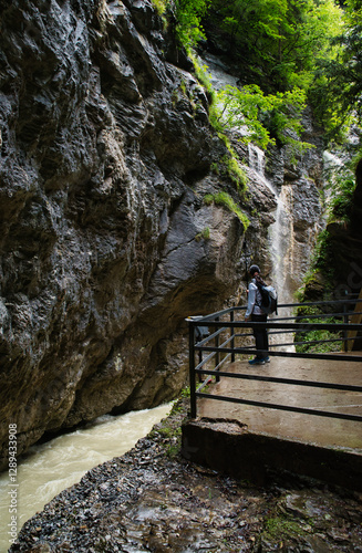 Girl hiker walking in the canyon of the Aar Gorge - Aareschlucht on the river Aare in the canton of Bern, Switzerland. With its footbridges for hiking. Interlaken
