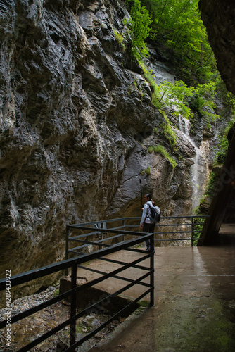 Girl hiker walking in the canyon of the Aar Gorge - Aareschlucht on the river Aare in the canton of Bern, Switzerland. With its footbridges for hiking. Interlaken
