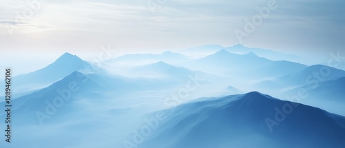 Layers of mist envelop distant mountain peaks, creating a serene and dreamlike landscape of blues and greys, capturing a sense of infinity.
