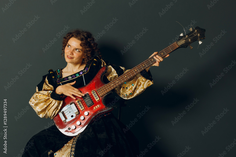 Portrait of a young adult woman playing music on electric guitar and dressed in a medieval dress