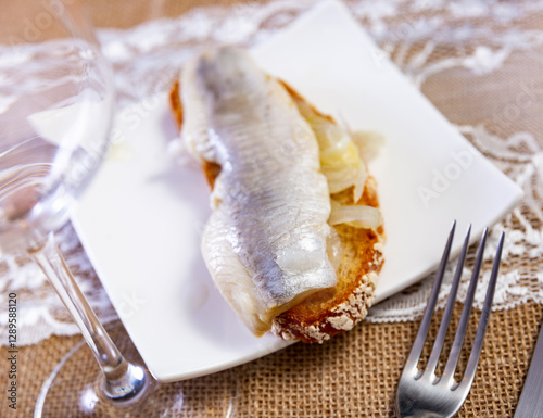 Appetizing sandwich from slice of wheat bread with soused herring fillet and marinated onion. Traditional russian snack photo