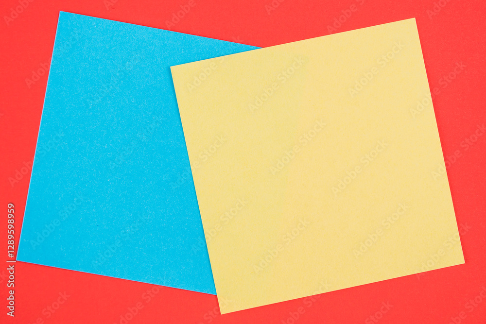 Blank memo square notes on background. Blank yellow and blue colored memo notes on red background background Blank memo square notes on background. Blank yellow and blue colored memo notes on red background background