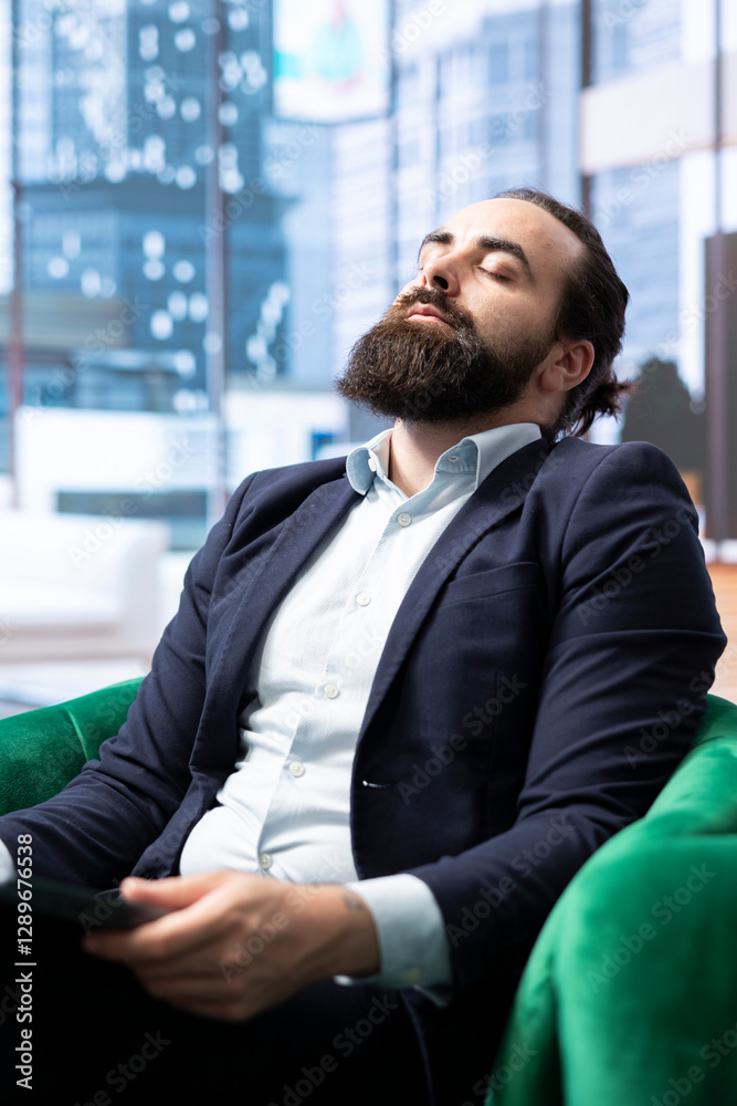 Stressed businessman sitting in his modern office and battling anxiety as he deals with losing money due to a declining hedge fund. Stock market risks causing corporate downfall. Stressed businessman sitting in his modern office and battling anxiety as he deals with losing money due to a declining hedge fund. Stock market risks causing corporate downfall.