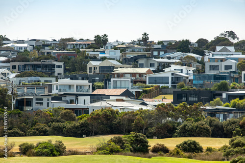 a coastal hillside community in Torquay, Victoria, with numerous modern homes and contemporary residential buildings built on sloping terrain. Concept of real estate and housing in regional Australia. photo
