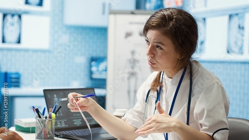 Healthcare professional sharing her medical expertise with a patient in a cabinet, reviewing x ray and MRI scans and focusing on accurate diagnostics and patient care. Diagnostic report. Camera A.