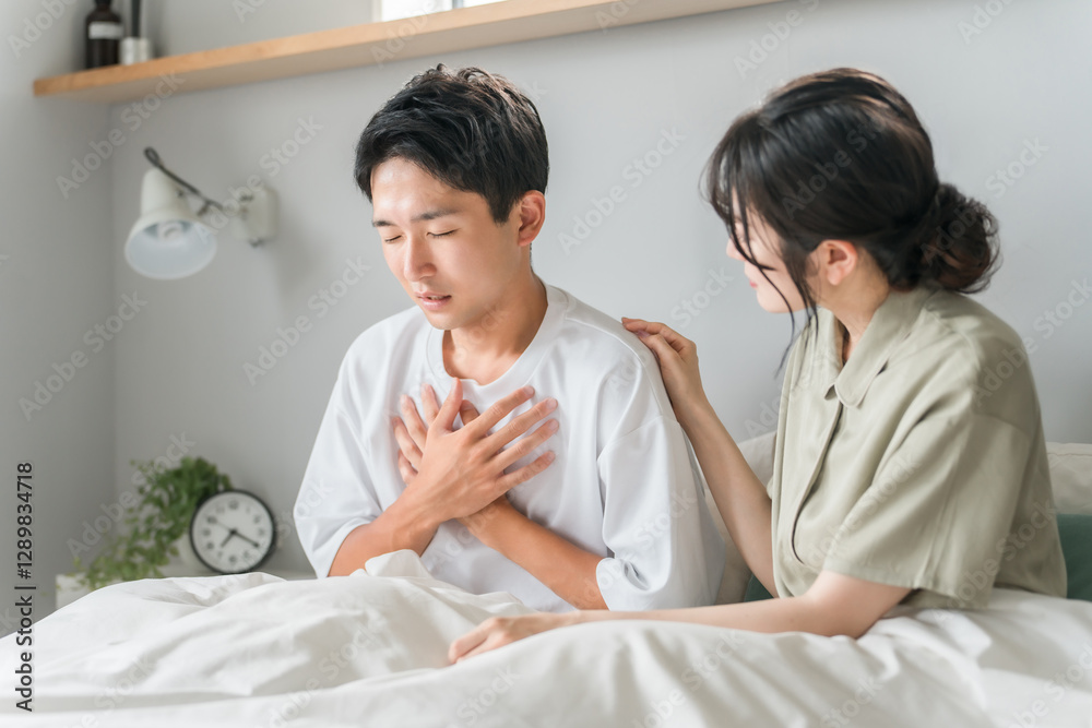 Obraz premium 朝寝室で胸痛・心臓病・肺炎に悩む男性と心配する女性・夫婦・カップル 