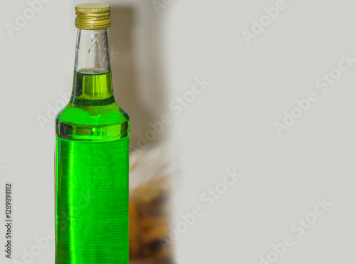 a bottle of melon-flavored green syrup in a glass bottle. an object with copy space for text